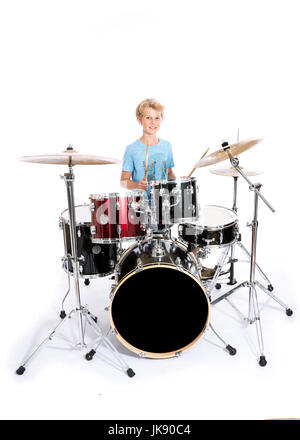 Teen blonde en bleu garçon joue de la batterie au studio de drumkit against white background Banque D'Images