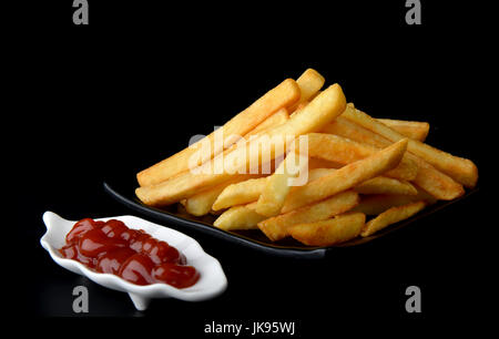 Sauce tomate et frites situé dans l'arrière-plan noir. Banque D'Images