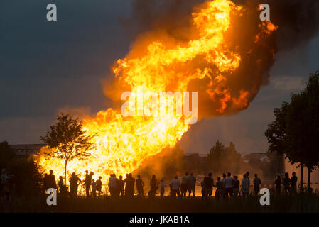 Silhouettes de personnes devant les grandes flammes de la colonne de feu d'une célébration du solstice et Midsummer Festival Banque D'Images