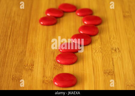 Plancher en bambou en bois portant un point d'interrogation faite avec pierres rouges en style Zen Banque D'Images