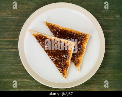 Tartiner sur des toasts extrait de boeuf contre un fond de bois vert Banque D'Images