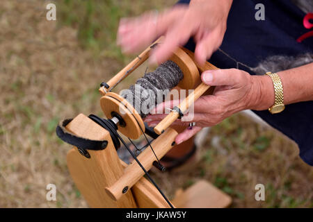 Close-up of woman's hands fil conducteur sur la roue tournante bobbin Banque D'Images