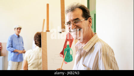 Les personnes âgées peinture pour passe-temps. Groupe des aînés à l'école d'art. Portrait of happy old woman, looking at camera. Banque D'Images