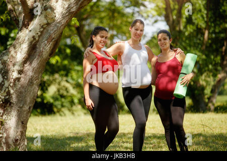 Portrait of happy pregnant women smiling après entraînement. Groupe de mamans s'entraîner avec des exercices de remise en forme et de yoga pendant la grossesse. Banque D'Images