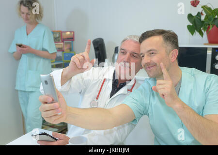 Smiling équipe de médecins et d'infirmières à l'hôpital prendre des selfies Banque D'Images