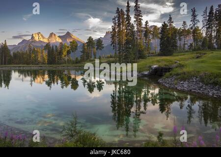 Silvertip Golf course distance de Three Sisters Canmore Mountain Peak. Blue Water calme reflet Rocheuses canadiennes Parc national Banff Paysage Banque D'Images