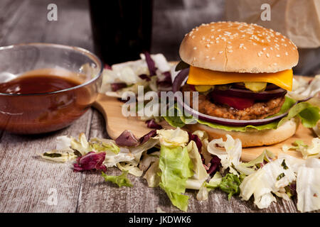 Délicieux burger sur plaque de bois Banque D'Images