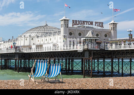 Deux chaises vides donnant sur la jetée de Brighton sur la côte sud de l'Angleterre. Banque D'Images