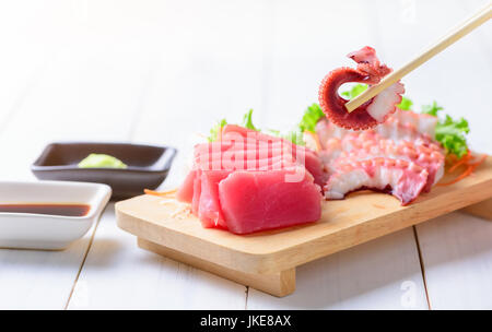 Calmars frais sur baguette et sashimi de thon blanc sur fond de bois, de la nourriture japonaise Banque D'Images