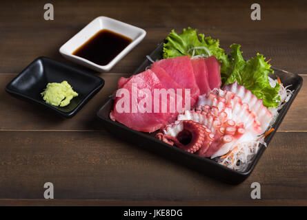 Le sashimi et le calmar, sur fond de bois, les aliments crus et les aliments japonais Banque D'Images