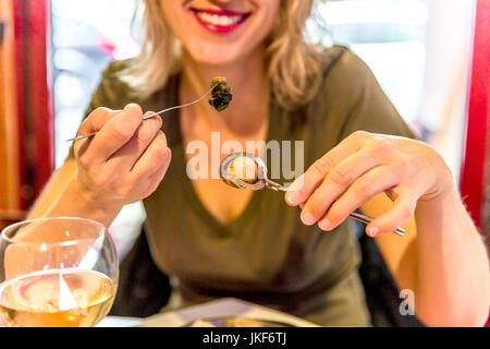 Femme mangeant des escargots Banque D'Images