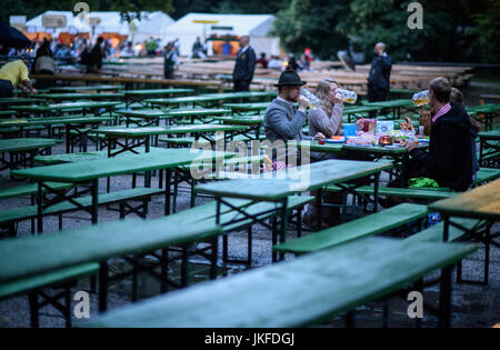 Munich, Allemagne. 23 juillet, 2017. Les gens boivent de la bière dans les heures tôt le matin lors de la traditionnelle "Kocherlball" au café en plein air à la Tour Chinoise dans les Jardins Anglais de Munich, Allemagne, 23 juillet 2017. Au 19e siècle les jeunes employés, les travailleurs des services, domestiques et autres prolétaires est venu à la danse à la "Kocherlball". Photo : Matthias Balk/dpa/Alamy Live News Banque D'Images