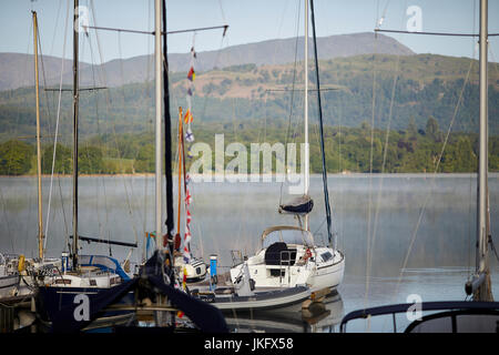 Matin brume sur un grand lac Windermere Cumbria en's Lake District National Park, atteint à peu de bateaux de plaisance en bois, près de Ambleside Banque D'Images