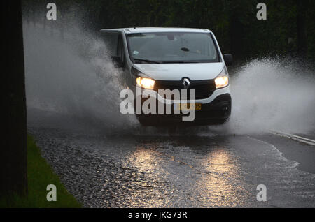 Sonderborg, Danemark - Juillet 23, 2017 : l'eau creux éclaboussures Van sur une route partiellement inondé pendant une forte pluie. Banque D'Images