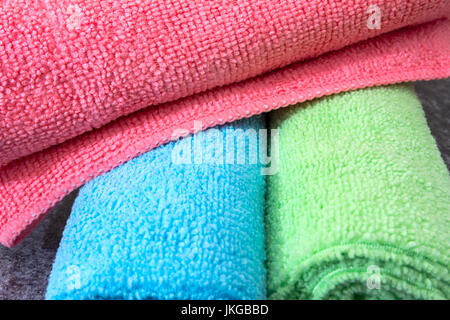 Rose, Bleu et vert de lingettes de nettoyage en microfibre enroulée. Généralement utilisée pour les travaux du ménage et nettoyage Banque D'Images