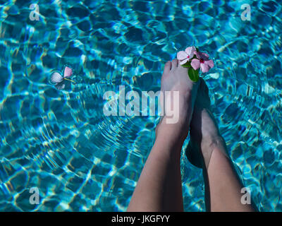 POV Jeune fille avec les pieds dans l'eau entre les orteils de fleurs Banque D'Images