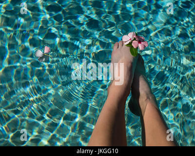 POV Jeune fille avec les pieds dans l'eau entre les orteils de fleurs Banque D'Images