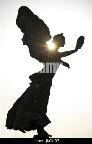 Close up vertical d'un ange statue silhouettée par le soleil. Banque D'Images