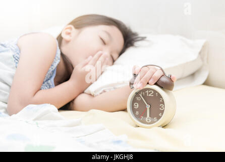 Fille main tendre la main pour le réveil matin Banque D'Images