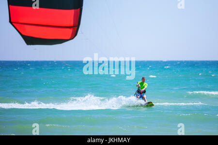 Jeune homme gai le kitesurf à blue sea Banque D'Images