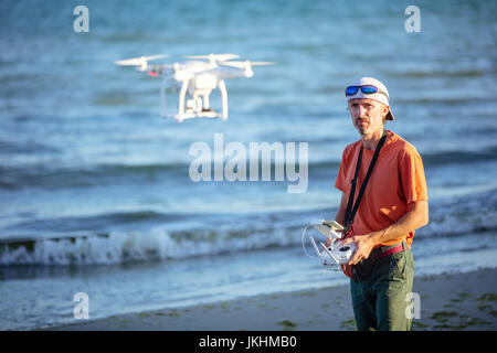 L'homme l'exploitation d'un drone avec commande à distance sur beach Banque D'Images