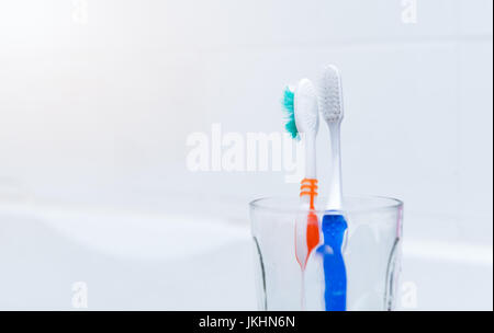 L'ancien et le nouveau verre à brosse à dents dans la salle de bains, concept de santé dentaire Banque D'Images