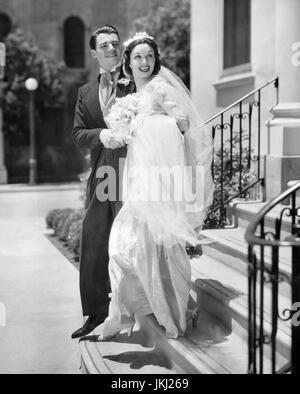 GAIL PATRICK (1911-1980) Actrice américaine et, plus tard, producteur de télévision de "Perry Mason" dans un shoot de mode en juillet 1936 pour un mariage gowen conçu par Travis Banton. Avec elle est primordiale contrat Wolfe acteur Hopper Banque D'Images