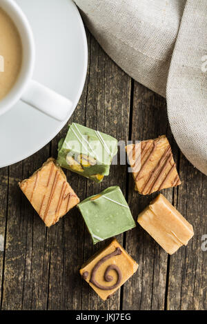 Bonbons au caramel coloré et tasse de café sur la table. Vue d'en haut. Banque D'Images