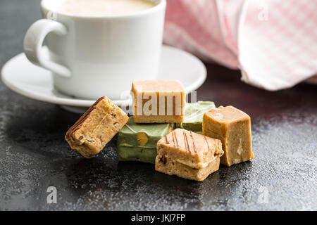 Bonbons au caramel coloré et tasse de café sur la table. Banque D'Images