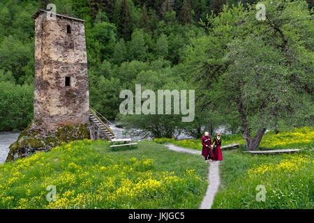 Georgian l'homme et la femme dans le costume national près d'une tour médiévale, la Géorgie. Banque D'Images