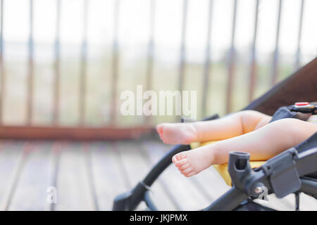 Pieds de bébé dans la poussette à l'extérieur Banque D'Images