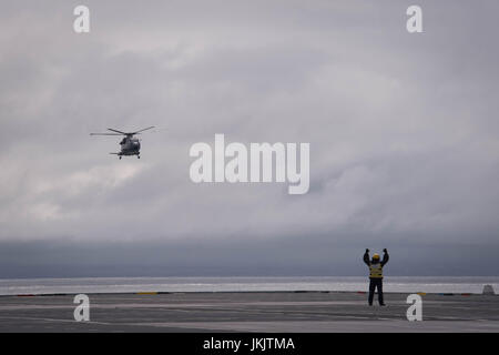 Guide de l'équipage d'un hélicoptère sur le pont du HMS Queen Elizabeth, comme la Royal Navy nouveau porte-avions appareille de Southampton pour la dernière d'une série d'essais en mer. Banque D'Images