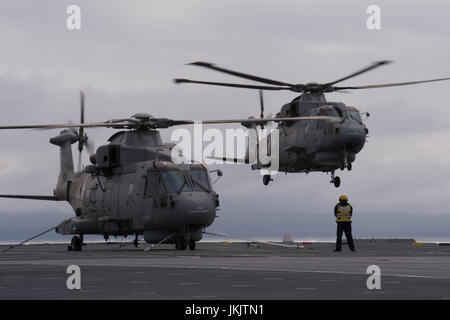 Guide de l'équipage d'un hélicoptère sur le pont du HMS Queen Elizabeth, comme la Royal Navy nouveau porte-avions appareille de Southampton pour la dernière d'une série d'essais en mer. Banque D'Images