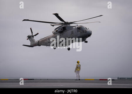 Guide de l'équipage d'un hélicoptère sur le pont du HMS Queen Elizabeth, comme la Royal Navy nouveau porte-avions appareille de Southampton pour la dernière d'une série d'essais en mer. Banque D'Images