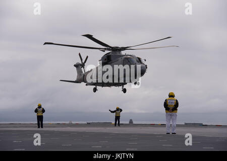 Guide de l'équipage d'un hélicoptère sur le pont du HMS Queen Elizabeth, comme la Royal Navy nouveau porte-avions appareille de Southampton pour la dernière d'une série d'essais en mer. Banque D'Images