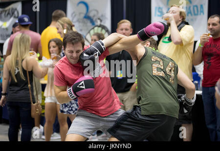 22 juillet 2017 - West Palm Beach, Floride, États-Unis - Jeremy Whittington, Boca Raton prend un poinçon espiègle de son ami Josh Bram, Rockville (Maryland) comme les deux essayé sur certains des gants de boxe au stand du Club de boxe de titre au Palm Beach Summer Beer Fest au South Florida Fairgrounds à West Palm Beach, Floride le 22 juillet 2017. Les amateurs de bière ne pouvait plus l'échantillon de 200 bières artisanales, le tout dans l'air climatisé ! Bram a dit, ''Nous avons essayé tous.'' The beer bash inclut les brasseries participantes : tronc tordu, Brasserie Brasserie complice et Ciderworks Ookapow, Brewing Company, Devo Banque D'Images