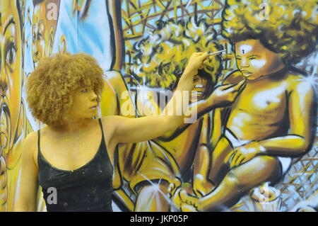 Aujourd'Brick Lane a vu un type différent de l'art comme une partie de l'œuvre d'art est venu à la vie dans la forme de l'artiste Holly Oluwo aussi realredwoman @à peindre l'or en alliance avec le street art magnifique par artiste Carleen Desozer. Le modèle superbe a déclaré "c'est une question de mettre les gens à ouvrir les yeux sur leur puissance intérieure' dans l'espoir d'encourager les autres à s'inspirer pour en savoir plus sur leur troisième œil aussi connu comme la glande pinéale. Plus d'informations peuvent être trouvées sur l'épiphyse couramment en ligne autant de soutien scientifique n'que c'est l'oeil nous voir avec nos rêves et peut-être plus. Banque D'Images