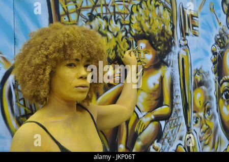 Aujourd'Brick Lane a vu un type différent de l'art comme une partie de l'œuvre d'art est venu à la vie dans la forme de l'artiste Holly Oluwo aussi realredwoman @à peindre l'or en alliance avec le street art magnifique par artiste Carleen Desozer. Le modèle superbe a déclaré "c'est une question de mettre les gens à ouvrir les yeux sur leur puissance intérieure' dans l'espoir d'encourager les autres à s'inspirer pour en savoir plus sur leur troisième œil aussi connu comme la glande pinéale. Plus d'informations peuvent être trouvées sur l'épiphyse couramment en ligne autant de soutien scientifique n'que c'est l'oeil nous voir avec nos rêves et peut-être plus. Banque D'Images