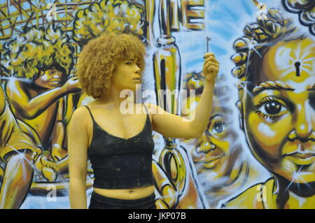 Aujourd'Brick Lane a vu un type différent de l'art comme une partie de l'œuvre d'art est venu à la vie dans la forme de l'artiste Holly Oluwo aussi realredwoman @à peindre l'or en alliance avec le street art magnifique par artiste Carleen Desozer. Le modèle superbe a déclaré "c'est une question de mettre les gens à ouvrir les yeux sur leur puissance intérieure' dans l'espoir d'encourager les autres à s'inspirer pour en savoir plus sur leur troisième œil aussi connu comme la glande pinéale. Plus d'informations peuvent être trouvées sur l'épiphyse couramment en ligne autant de soutien scientifique n'que c'est l'oeil nous voir avec nos rêves et peut-être plus. Banque D'Images