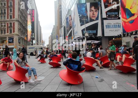New York, États-Unis. 24 juillet, 2017. New York, NY, US. -- 24 juillet 2017-- Les jeunes et les jeunes de cœur les visiteurs de Times Square s'arrêta un moment de plaisir avec le midi Magis Chaise. filé Le filé debout est une fascinante chaises chaise qui ressemble plus à un navire sculpturale d'un siège. Mais lorsqu'il se penche sur le côté, elle forme un siège confortable et fonctionnel qui vous permet d'latéralement ou tourner autour. Credit : Ronald G. Lopez /DigiPixsAgain.us/Alamy Live News Banque D'Images