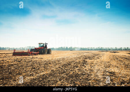 Tracteur moderne dans le domaine des complexes pour les labours. Le concept de travail dans un champs et industrie de l'agriculture. Banque D'Images