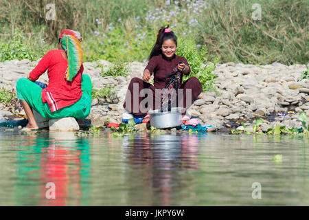 Les népalaises à laver les vêtements dans une rivière, pour un usage éditorial uniquement, district de Chitwan, Népal Banque D'Images