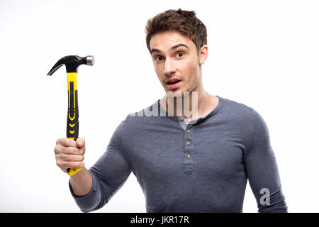 Handsome man holding hammer isolé sur blanc, concept outils bricoleur Banque D'Images