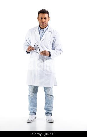 Jeune médecin en blouse blanche et gestes looking at camera isolated on white Banque D'Images