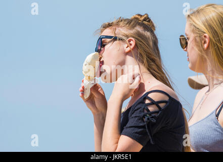 Fille de manger un cornet de crème glacée par une chaude journée d'été. Banque D'Images