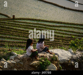 Mu Cang Chai, Vietnam - Mai 28, 2016. Les filles hmongs assis sur champ de riz à Mu Cang Chai, au Vietnam. Mu Cang Chai est célèbre pour ses 700 hectares de terrasses Banque D'Images