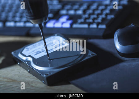 Close-up de percer sur le disque dur par clavier de l'ordinateur à la table Banque D'Images