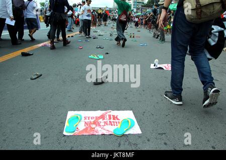 Aux Philippines. 24 juillet, 2017. Un art de l'installation de pantoufles que représente le décès de jeunes enfants victimes de l'assassinat extra judiciaire (EJK) pendant l'opération contre les drogues illégales le long Tokhang Commonwealth Avenue pendant les milliers de groupe multi-sectorielle des groupes éventuels de mars Chambre des Représentant à procéder à leur propre version de SONA ng Bayan durant la 2ème l'état de la Nation du Président Rodrigo Roa Dutertwe à l'intérieur de Pambansa Batasan à Quezon City le 24 juillet 2017. Credit : Gregorio B. Dantes Jr./Pacific Press/Alamy Live News Banque D'Images