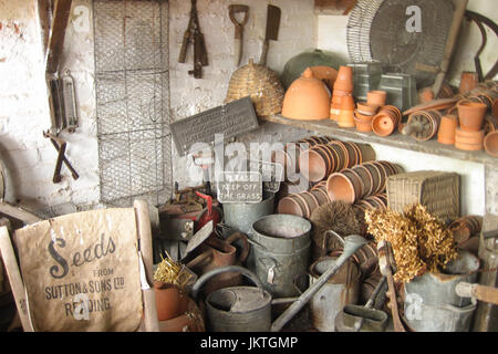 Intérieur du hangar rustique avec des pots en terre cuite empilés et d'outils de jardinage vintage Banque D'Images