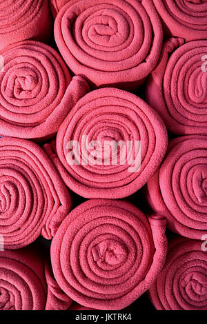 Pile de roulé de couleur rose, couvertures en molleton pour photo verticale ou fond texture tissu Banque D'Images